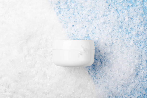 istock White jar with face cream on a white and blue background with artificial snow. Cosmetic moisturizing winter product. Copy space, top view, flat lay. 1166322995