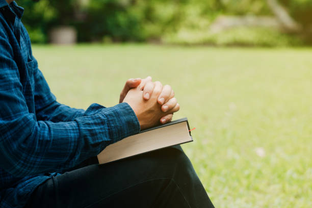 Christians and Bible study concept.Young man sitting and prayer on bible.copy space