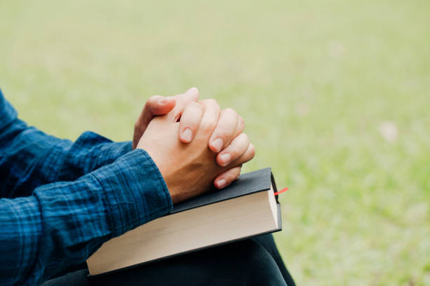 istock Christians and Bible study concept.Young man sitting and prayer on bible.copy space 1166323081