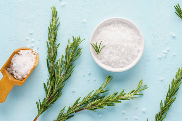 istock Coarse sea salt and fresh rosemary on light blue background. 1166325109