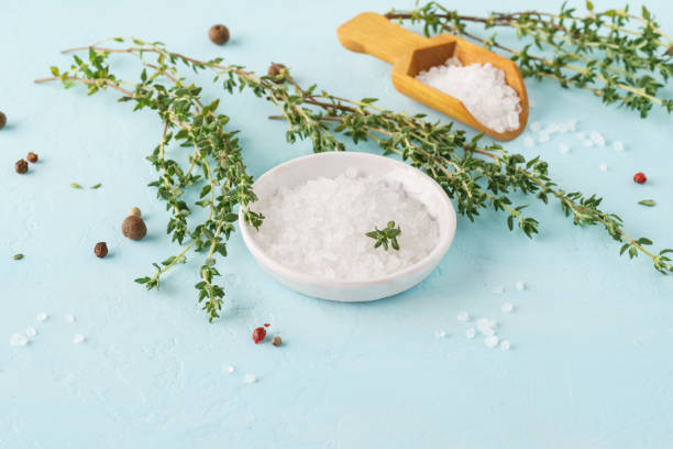 istock Coarse sea salt, pepper and fresh thyme on blue background. 1166325809