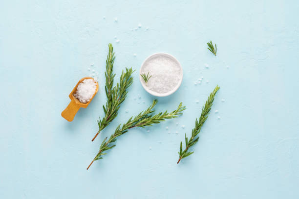 istock Coarse sea salt and fresh rosemary on light blue background. 1166325990