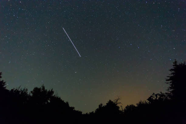 istock night starry sky with iss track above the forest silhouette 1166330455