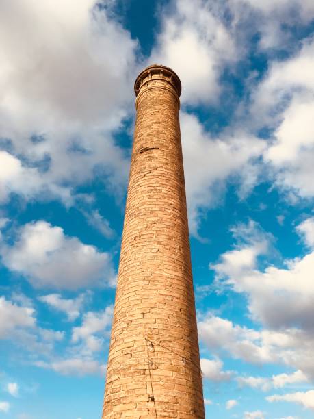 istock Tall brick chimney on a white and blue background 1166332418