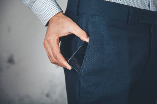 istock man hand phone on poket on abstract background 1166334087