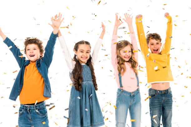 istock four happy kids waving hands under confetti isolated on white 1166335130
