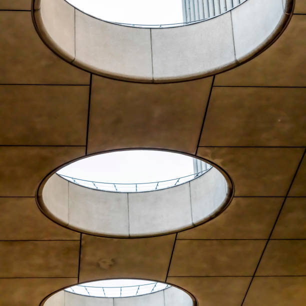 istock Square frame Close up of round skylights in a row viewed from inside a building 1166335252