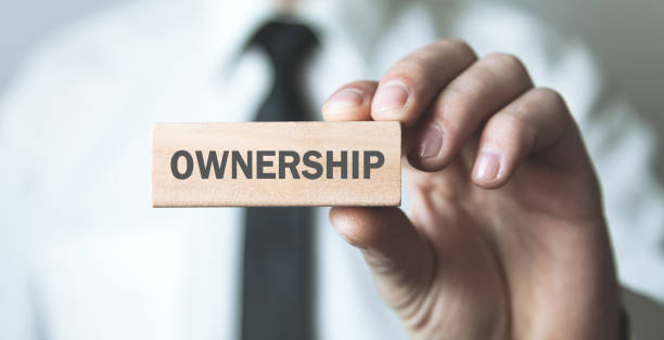 istock Man holding wooden block with a Ownership text. 1166339249
