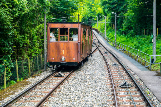 Stuttgart, Germany, July 18, 2019, Ancient brown wooden funicular cable car driving down silently the rails from heslach forest cemetery to the city through green forest