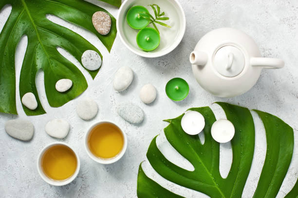 istock Oriental style  teapot on light   background with green monstera 1166344266