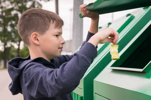 istock boy throws a piece of apple into the trash tank, close-up 1166345218