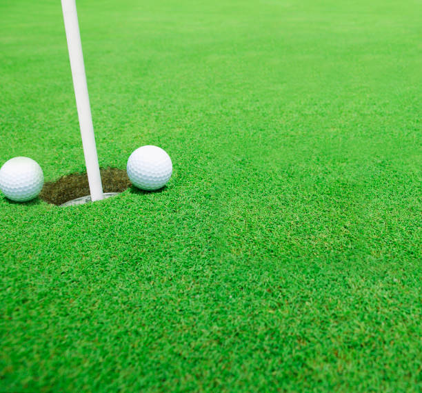 istock Golf balls near the hole close up 1166346642
