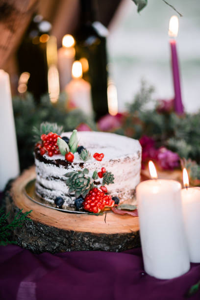 istock Delicate wedding white cake decorated with pomegranate. 1166348842