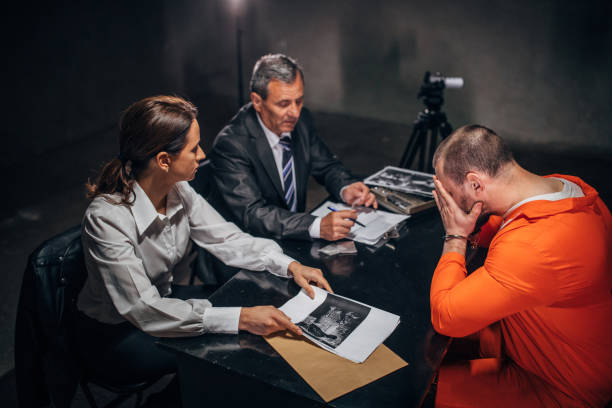 istock Two detectives and male prisoner in interrogation room 1166349822