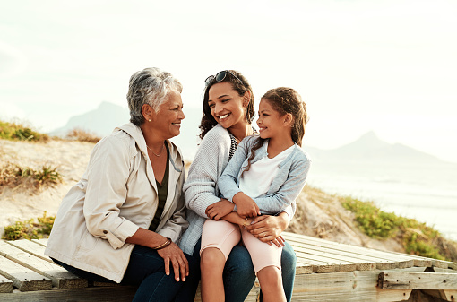 Shot of an adorable little girl spending the day with her mother and grandmother at the beach