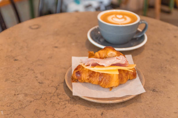 istock Coffee and croissant sandwich on stone table. French breakfast. 1166355368