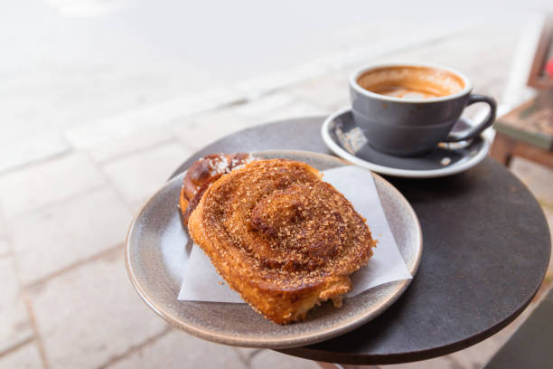 istock Warm cinnamon bun with icing sugar with cup of coffee 1166355429