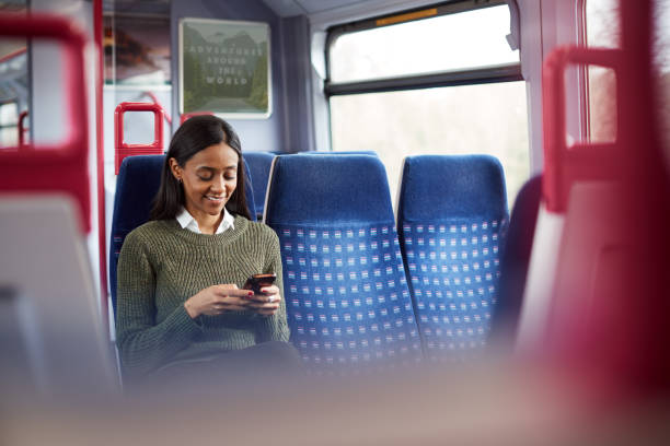 istock Female Passenger Sitting In Train Looking At Mobile Phone 1166358122