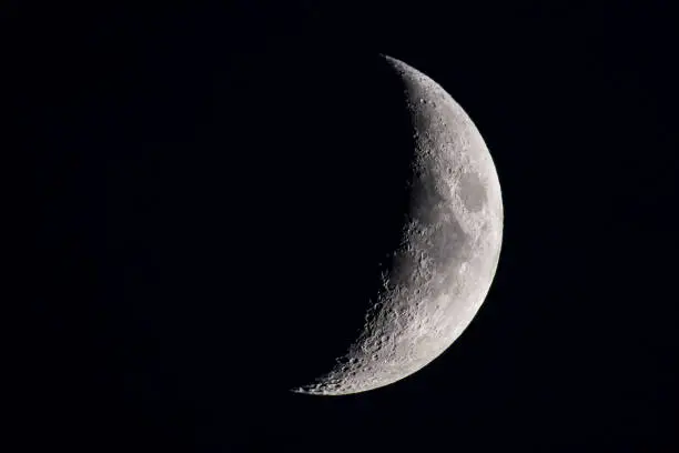 Moon with a clearly visible moon surface in the dark night sky. The moon is waxing towards full moon.