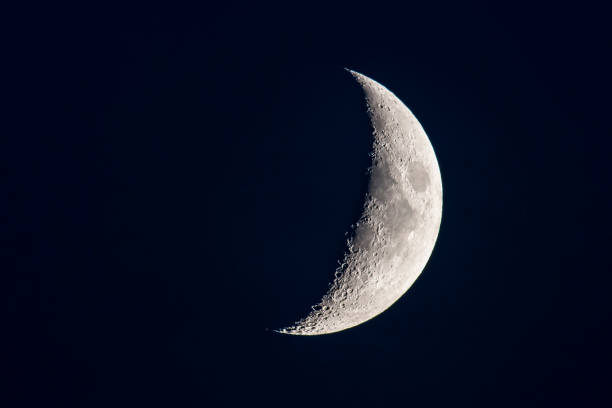luna con una superficie lunar claramente visible en el cielo nocturno oscuro. - luna creciente fotografías e imágenes de stock
