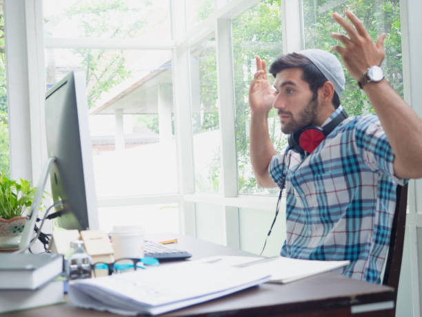 istock young man working at home and thinking something ,businessman works on his computer to get all his business 1166359237