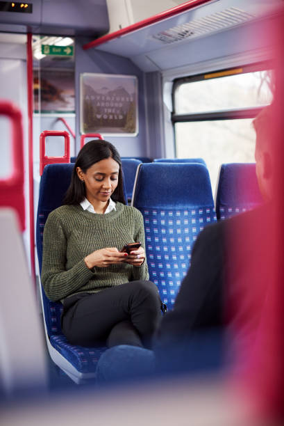 istock Female Passenger Sitting In Train Looking At Mobile Phone 1166360121