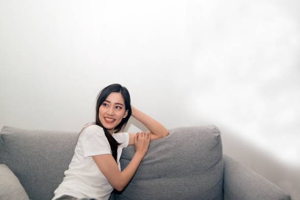 istock Asian woman relaxed and resting breathing fresh on sofa. 1166360375