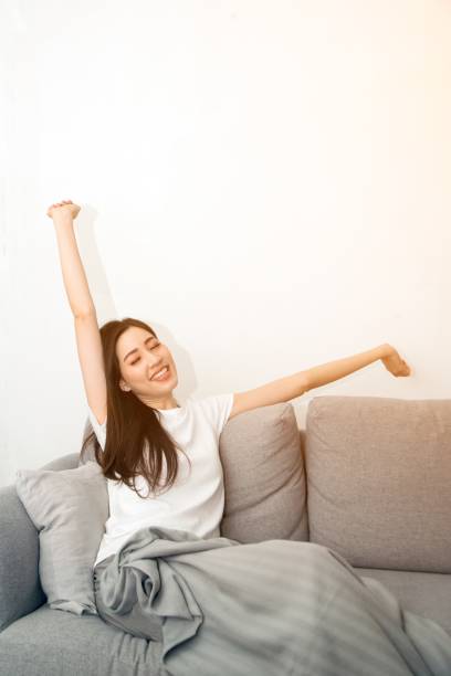 istock Asian woman relaxed and resting breathing fresh on sofa. 1166360389