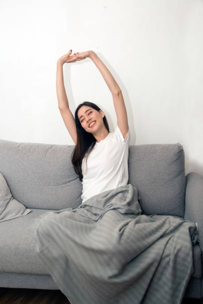 istock Asian woman relaxed and resting breathing fresh on sofa. 1166360398