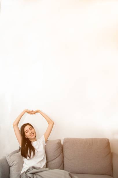 istock Asian woman relaxed and resting breathing fresh on sofa. 1166360401