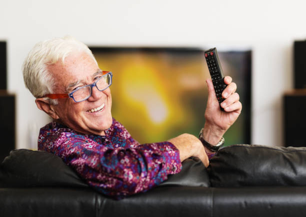 istock Smiling senior man holding TV's remote control 1166360425