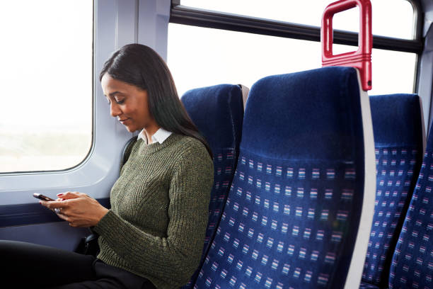 istock Female Passenger Sitting In Train Looking At Mobile Phone 1166361119