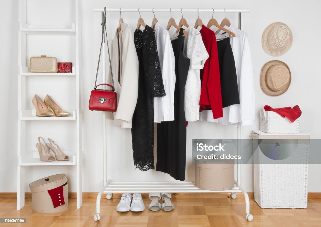 Modern wardrobe interior with different female clothes, hats and shoes Clothing Stock Photo