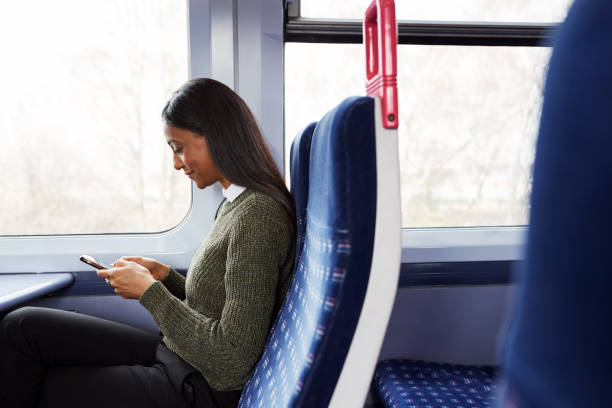 istock Female Passenger Sitting In Train Looking At Mobile Phone 1166361801