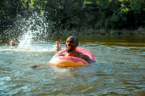 istock Happy man having fun, laughting and swimming in river 1166361911