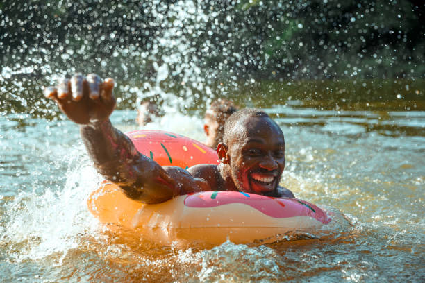 istock Happy man having fun, laughting and swimming in river 1166361916