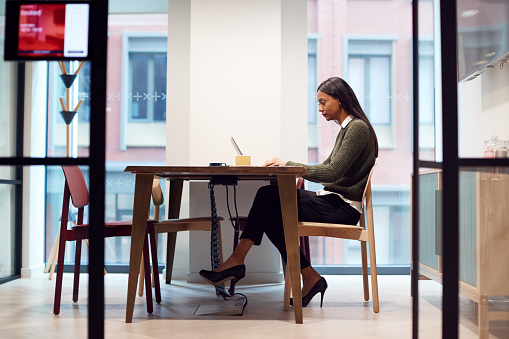 Mujer de negocios que trabaja en el ordenador portátil en el escritorio en la sala de reuniones photo