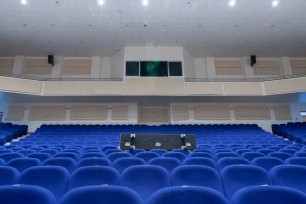Big white theatre or conference hall with blue seats towards the control room.