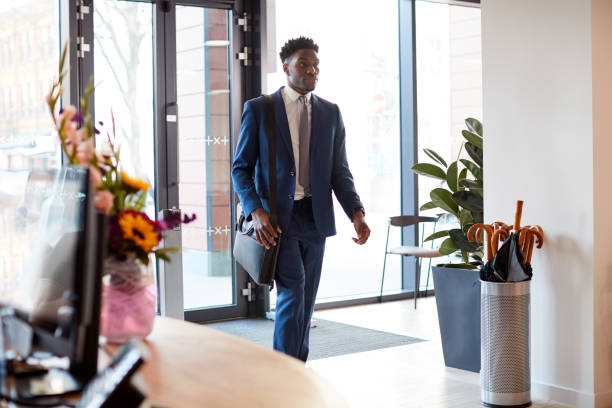 Businessman Arriving For Work At Office Walking Through Door Businessman Arriving For Work At Office Walking Through Door day 1 stock pictures, royalty-free photos & images