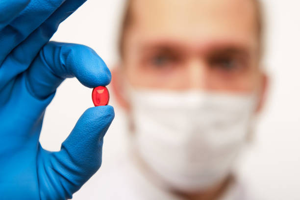 istock Pharmacist holding small red pill in hand 1166364789