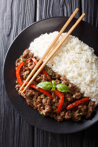 istock basil beef with bell pepper in a spicy sauce served with rice close-up on a plate. Vertical top view 1166365056
