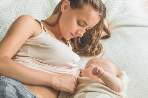 Portrait of a mom and breast feeding baby Portrait of a mom and breast feeding baby. Concept breast feeding. cute boy show love symbol hand stock pictures, royalty-free photos & images