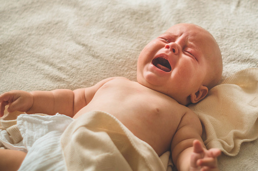 Llorando bebé recién nacido hambriento acostado en la cama. Me encanta el bebé. Bebé y madre recién nacidos photo