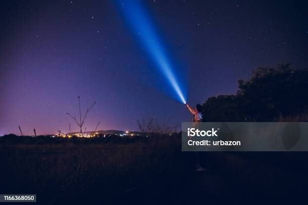 Man Lighting Up The Stars Stock Photo - Download Image Now - Lighting Equipment, Flashlight, Night