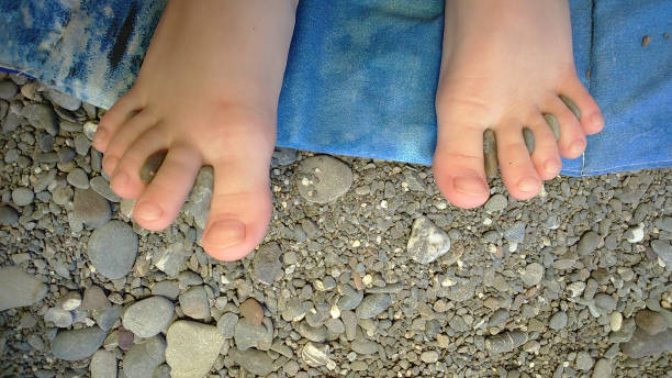 pies de un niño en la orilla del mar. - barefoot behavior toned image close up fotografías e imágenes de stock