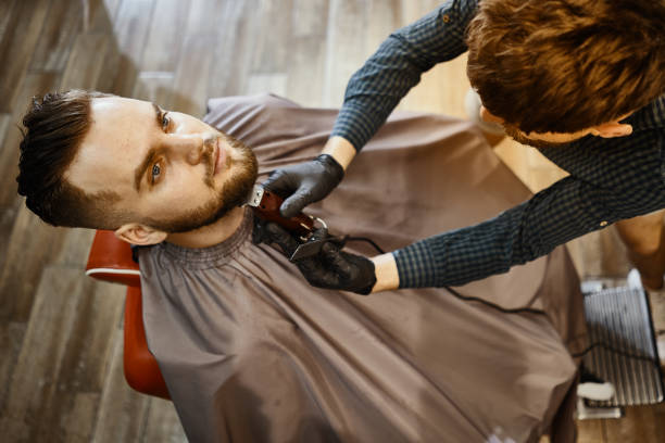 istock a guy doing a haircut and styling a beard 1166369999