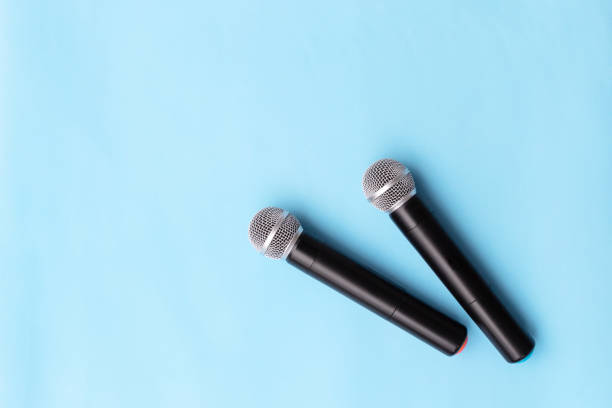 istock Two vocal silver microphone wireless for audio recordings, karaoke on blue background. 1166370085