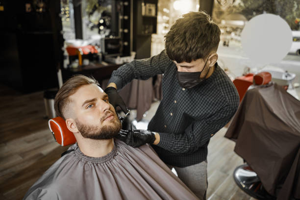 a guy doing a haircut and styling a beard - 4605 imagens e fotografias de stock
