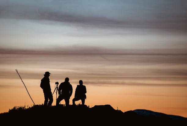 istock Three photographers taking photo against sunset 1166370973