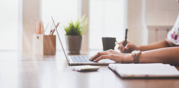 vue de côté de jeune femme d'affaires travaillant sur son projet - laptop keyboard photos et images de collection